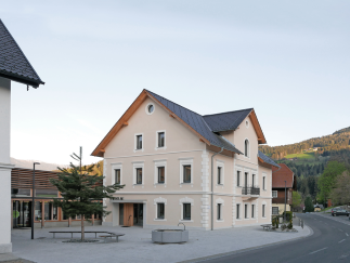 Neugestalteter Dorfplatz mit Aufenthaltsmöglichkeiten, Brunnenanlage und Schattenbäumen